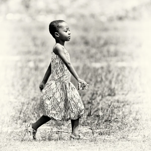 Ghanaian girl walks throug the field — Stock Photo, Image