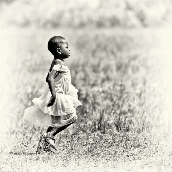 Ghanansk flicka i en vit klänning danser i fältet — Stockfoto