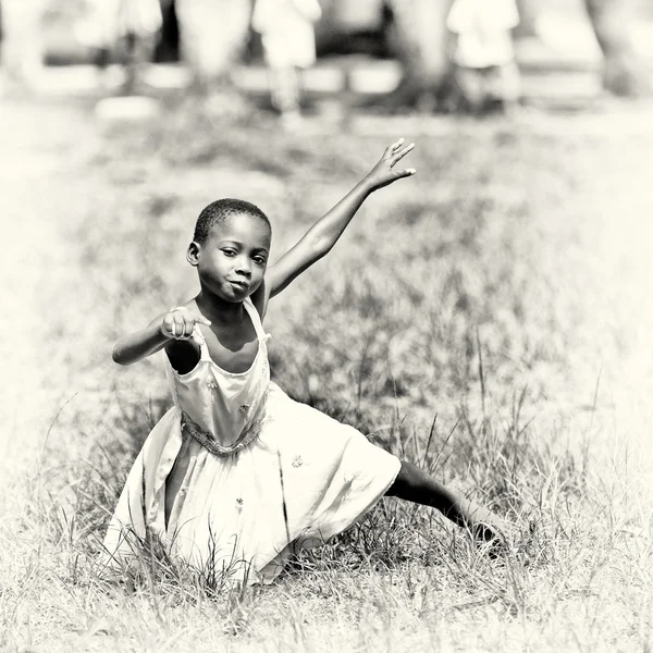 Little Ghanaian girl dances in the field — Stock Photo, Image