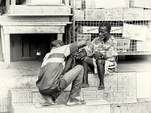Gana'lı bir adam yaşlı bir adamın tırnağı keser — Stok fotoğraf