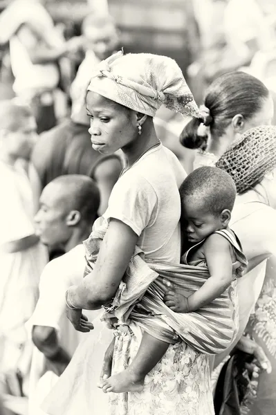 En liten Ghanansk baby sover på rygg mor — Stockfoto