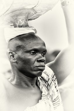 A man from Ghana carries his stuff on his head clipart