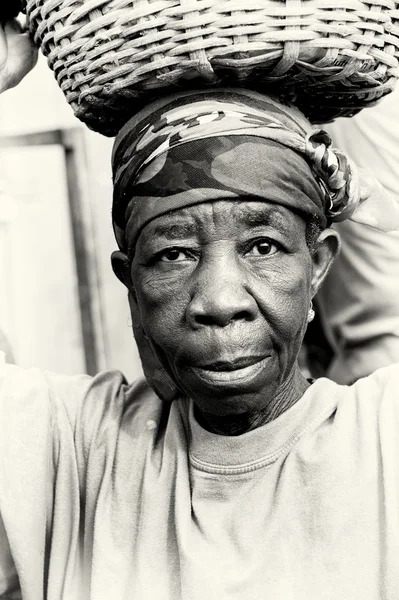 Eine alte ghanaische Frau mit einem Korb auf dem Kopf — Stockfoto