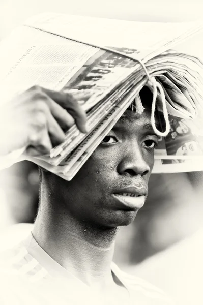 Gazetelerin baş üzerinde bir blok ile Gana'lı bir adam — Stok fotoğraf