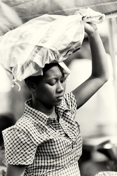 Una mujer ghanesa lleva un montón de cosas sobre la cabeza —  Fotos de Stock