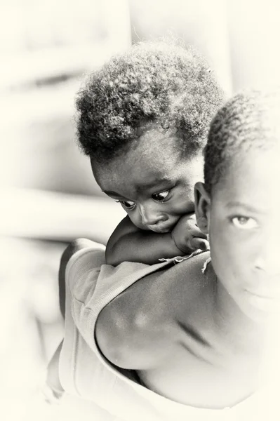 Kleine babyjongen uit ghana op de achterkant van zijn broer — Stockfoto