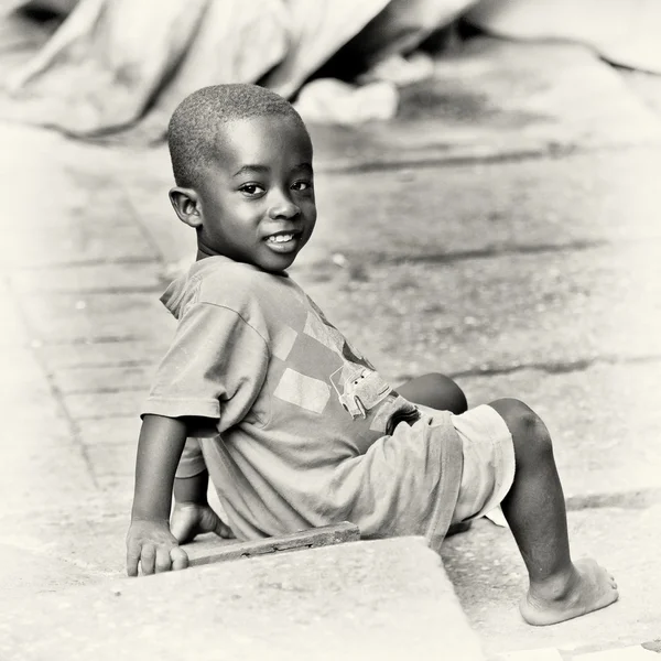 Pequeño chico ghanés se sienta en el suelo —  Fotos de Stock