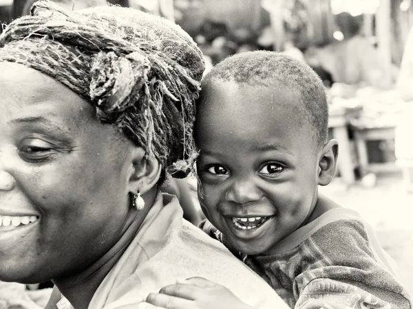 Lindo chico sonriente de Ghana en la espalda de su madre —  Fotos de Stock