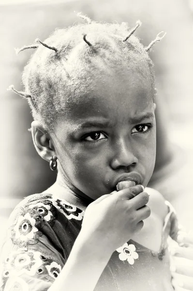 ガーナからの小さな女の子のポーズし、食べる — ストック写真