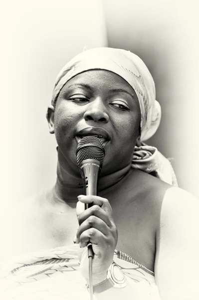 Una mujer de Ghana canta una canción con un micrófono — Foto de Stock