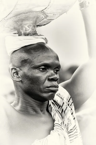 Een man uit ghana draagt zijn spullen op zijn hoofd — Stockfoto