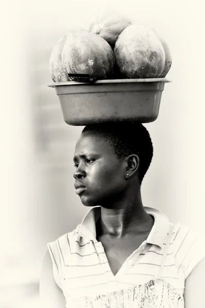 Uma mulher de Gana carrega os melões na cabeça — Fotografia de Stock