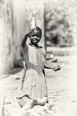 A Ghanaian girl holds two bottles of water clipart