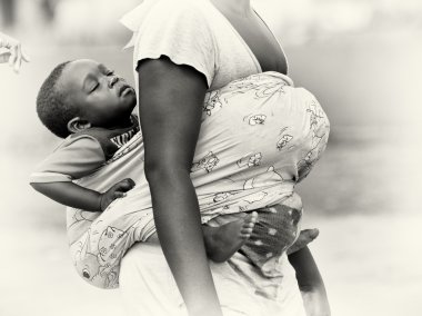Gana'lı bir çocuk annesi tarafından arkasında yapılır iken uyur