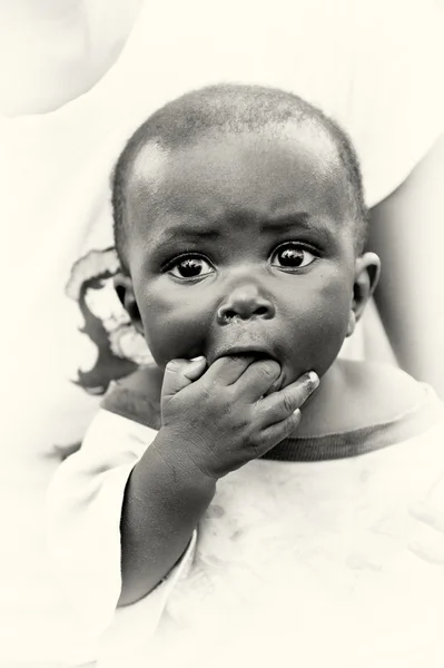 Pequeno menino ganês colocar dois dedos na boca — Fotografia de Stock