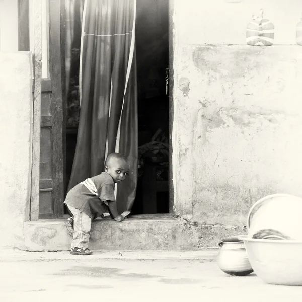 Маленький мальчик из Ганы пытается войти в дверь — стоковое фото