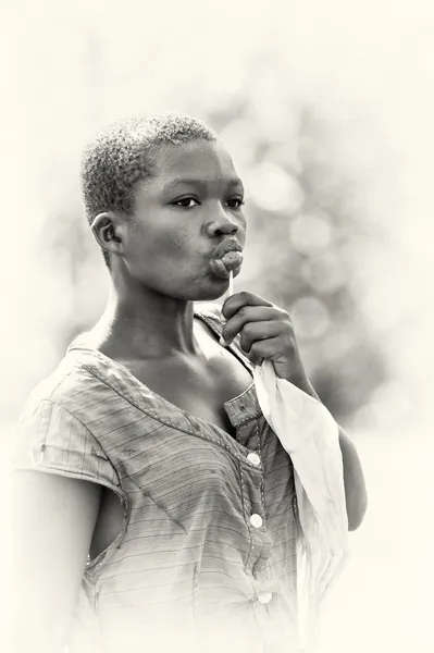 Una chica ghanesa chupa un chupa chups — Foto de Stock