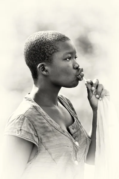 Ett porträtt av en ghanansk tjej suger en chupa chups — Stockfoto