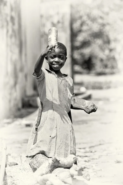 A Ghanaian girl holds two bottles of water — Stock Photo, Image
