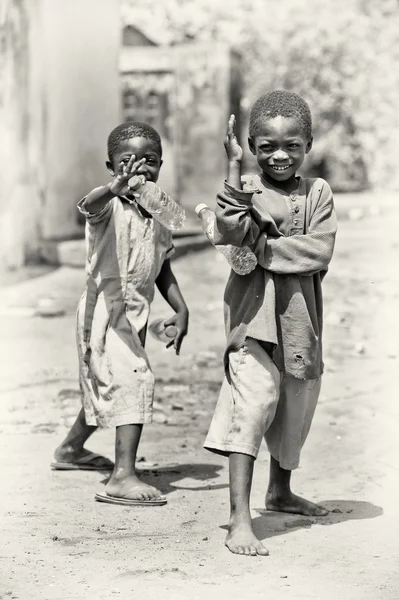 Två glada Ghanansk pojkar med flaskor vatten posera för kameran — Stockfoto