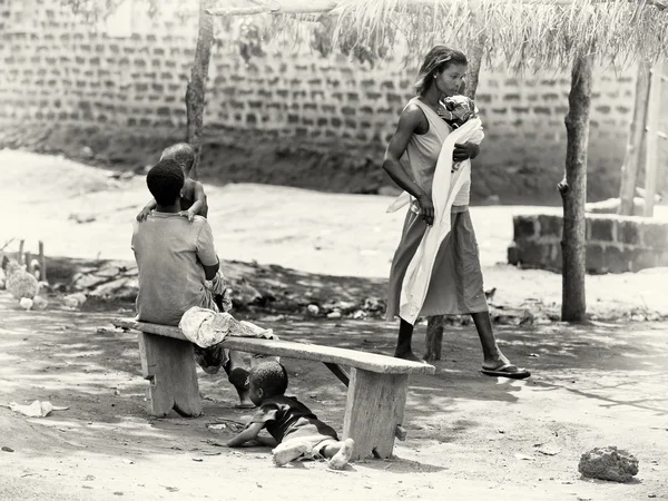 Мужчина со своим ребёнком, женщина с ребёнком и ребёнок под скамейкой. Гана . — стоковое фото