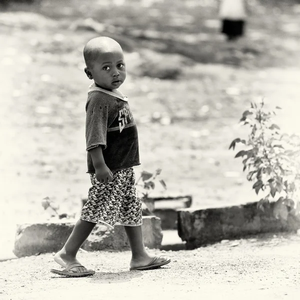 A little Ghanaian boy walks by the road — Stock Photo, Image