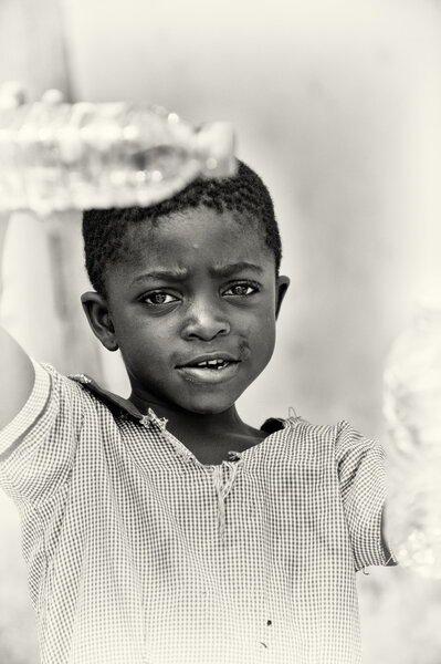 A Ghanaian little boy with a bottle of water