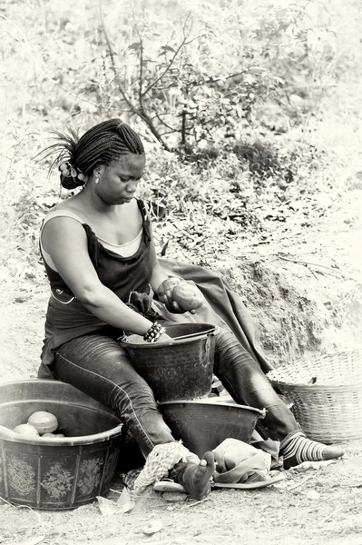 Uma mulher ganesa se senta e cuida da comida — Fotografia de Stock