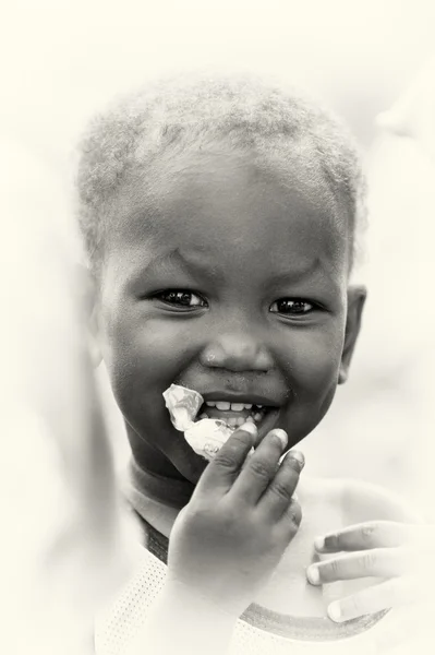 Маленький ганский мальчик ест конфеты. — стоковое фото