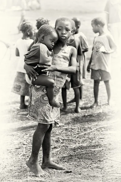 Hermanita sostiene a su hermano en Ghana — Foto de Stock