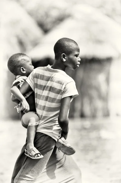 Chłopiec ghański prowadzi jego młodszy brat — Zdjęcie stockowe