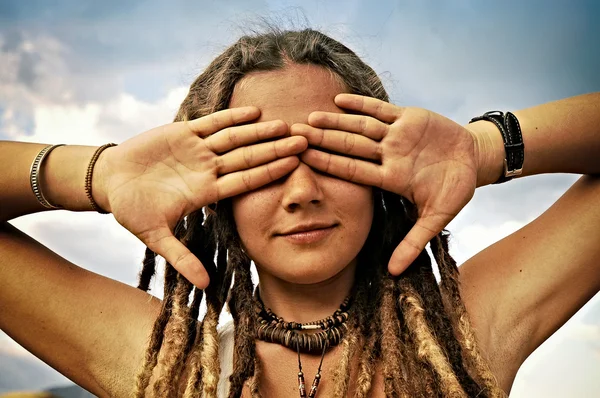 Pretty girl with dreadlocks closing her eyes with her hands — Stock Photo, Image