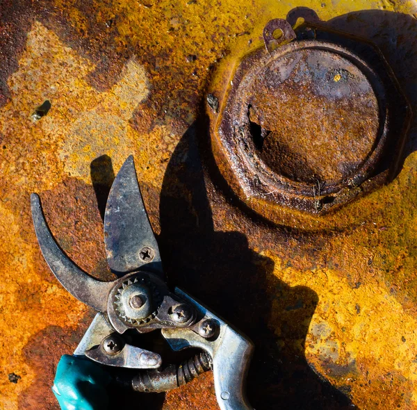 Rusty metal background and tool with a shadow — Stock Photo, Image