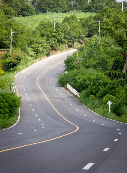 stock image The road curves up the mountain. Line yellow and white road.