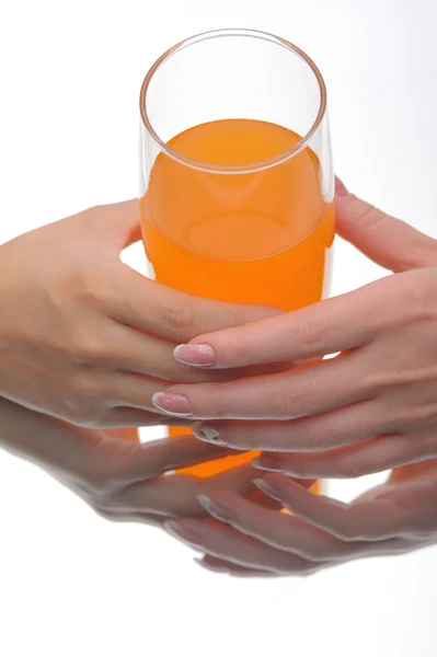 Dos manos sosteniendo el vaso de líquido naranja — Foto de Stock