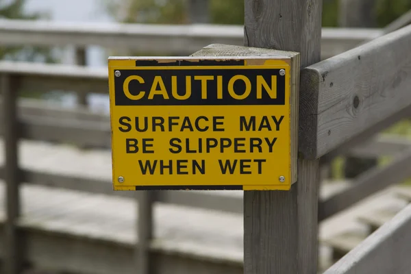 La superficie de precaución puede ser resbaladiza cuando está mojada . —  Fotos de Stock