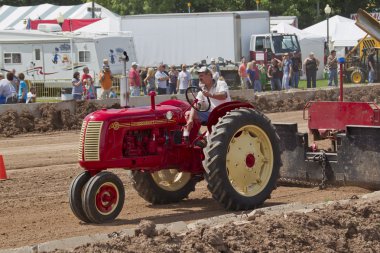 Red & Yellow Cockshutt Tractor pulling Tracks clipart