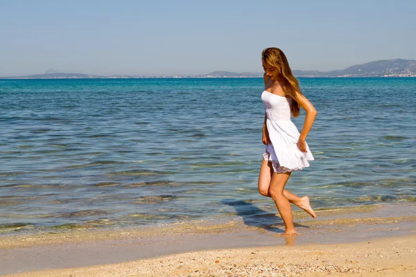 Девушка идет по белому песчаному пляжу — стоковое фото