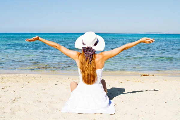 Молодая женщина сидит на пляже — стоковое фото