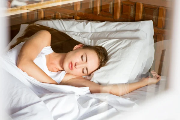 Junge Frau schläft auf dem Bett — Stockfoto