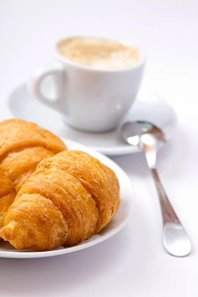 Tasse Kaffee und Croissant auf der Untertasse — Stockfoto