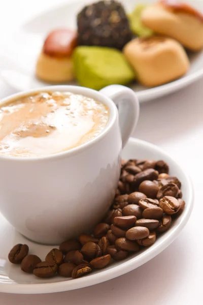Šálek kávy a sladkostí na talířku — Stock fotografie