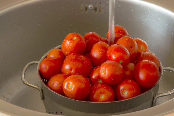 Los tomates en el cedazo con las gotas de agua — Foto de Stock