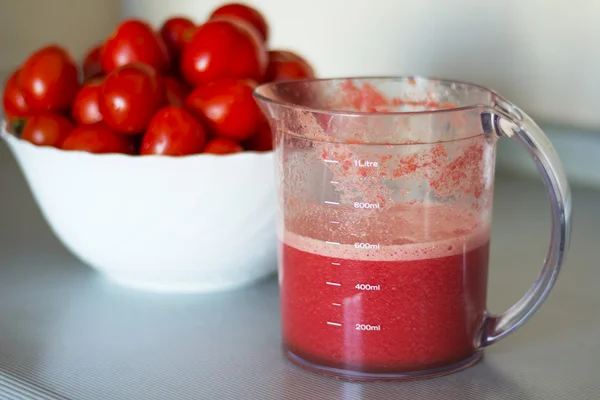 stock image Fresh tomato juice in a measured mug.