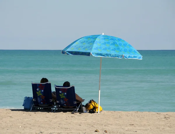 Liegestühle und Sonnenschirm — Stockfoto
