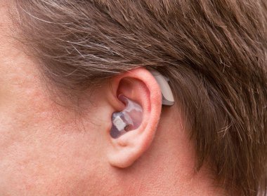 Man's ear with hearing aid clipart