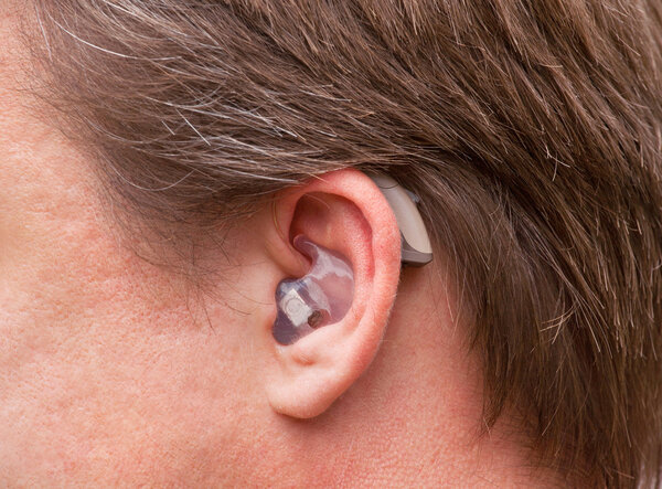 Man's ear with hearing aid