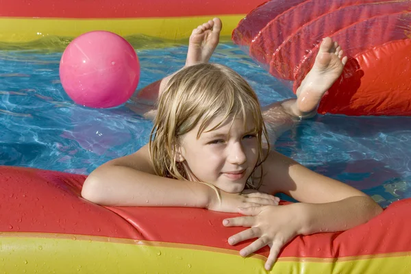 Menina jogando em um brinquedo inflável — Fotografia de Stock