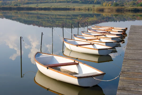 Білі човни на поверхні спокійної води . — стокове фото