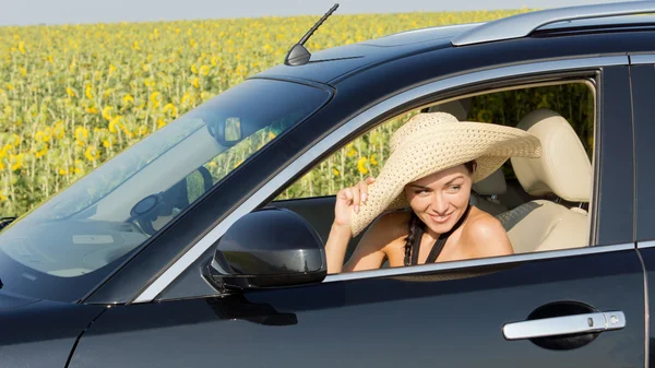 Жінка в солом'яному сонячному капелюсі в машині — стокове фото